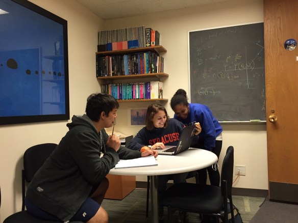 Samantha Usman (center) waits with student researchers Steven Reyes and Amber Lenon wait to see the closed-box results of Usman’s analysis.